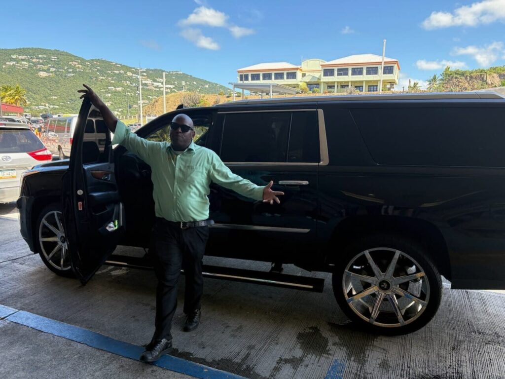 Professional driver standing beside luxury SUV for private airport transfer in St. Thomas USVI